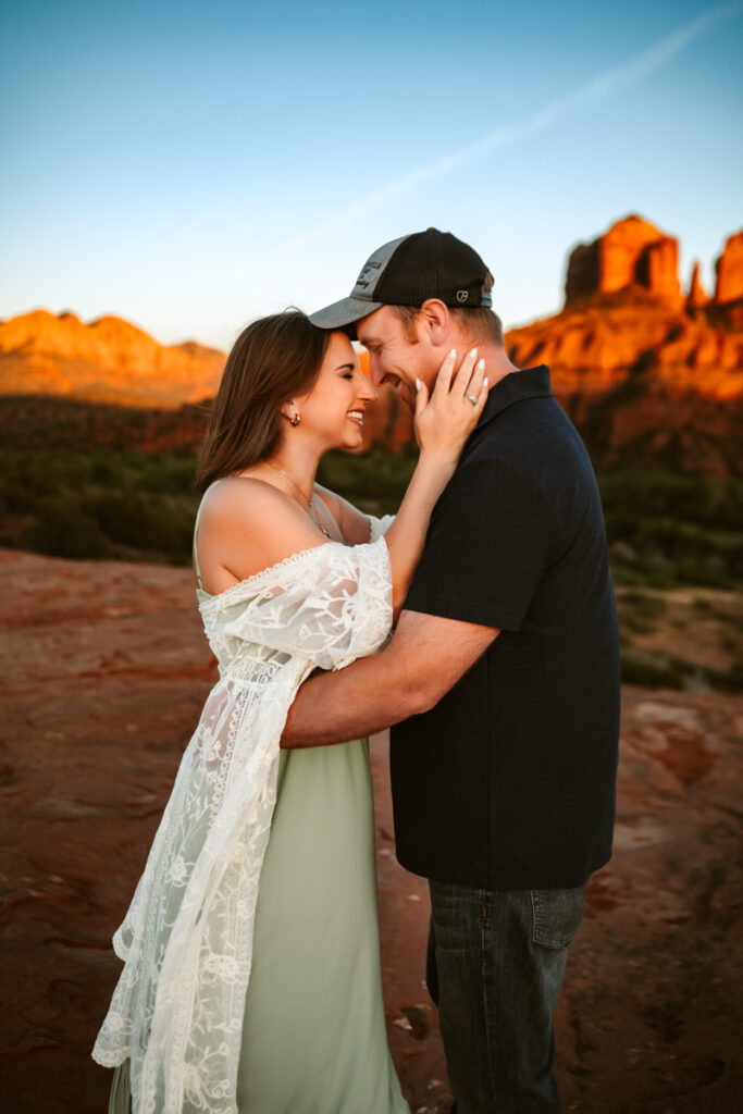 Couple hugging in front of cathedral rock in sedona.