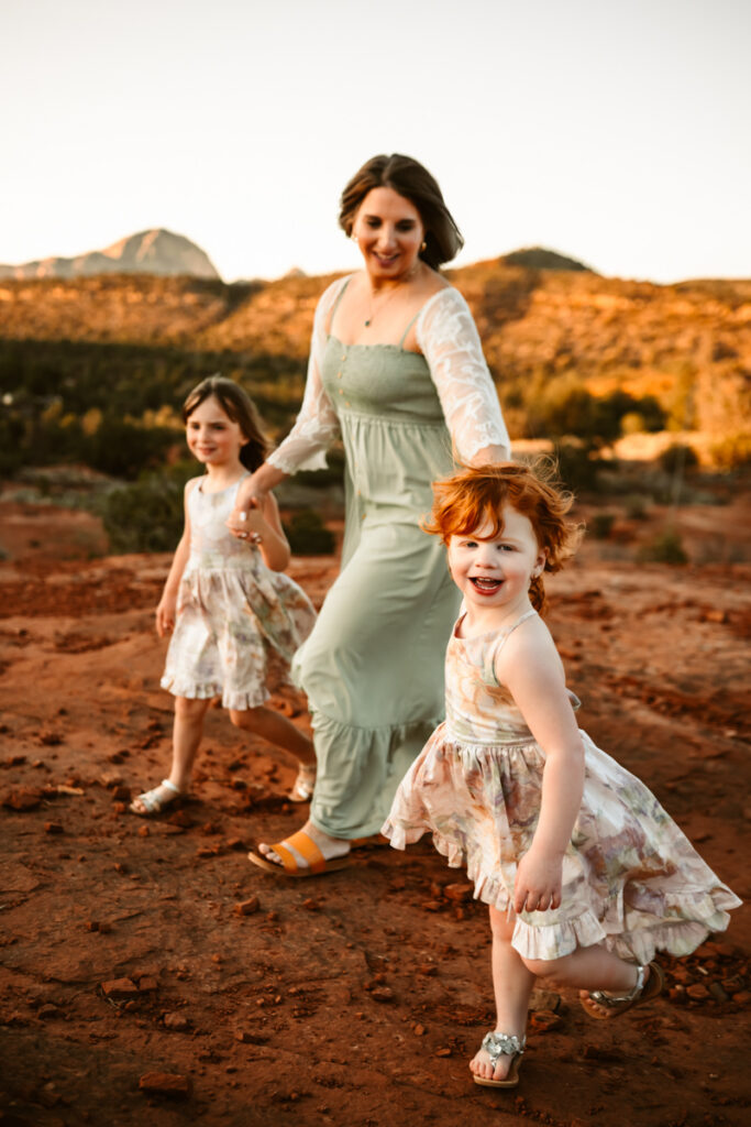 Daughters walking with their mother in the red rocks of sedona.