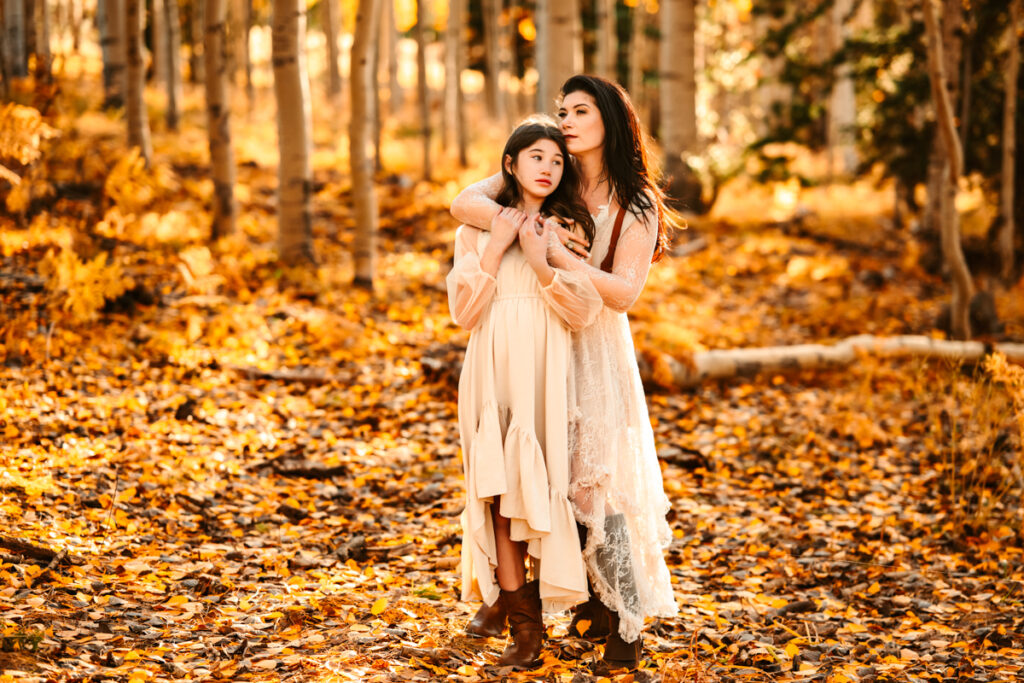Mother daughter hugging in the aspen trees of flagstaff.
