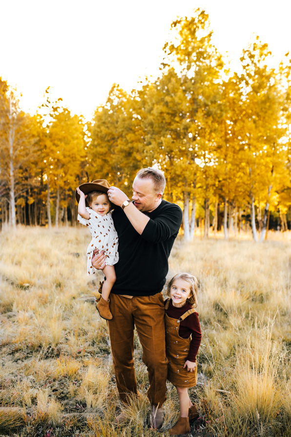 Dad playing with his daughters in the aspens with fall colors in Flagstaff at Aspen Corner on Snowbowl.