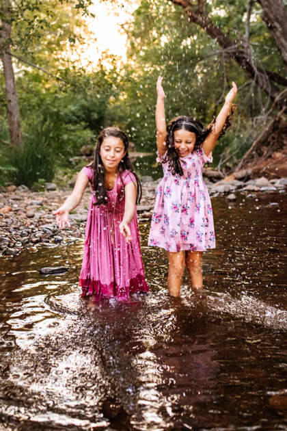 Sisters spashing in Oak Creek Canyon in Sedona Arizona by Annie Bee Photography.