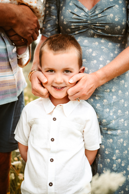 Boy smiling for a portrait while mother squeezes his cheeks in Flagstaff, Arizona.