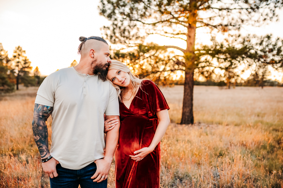 Expecting mom gets a kiss from her husband at Buffalo park in Arizona.