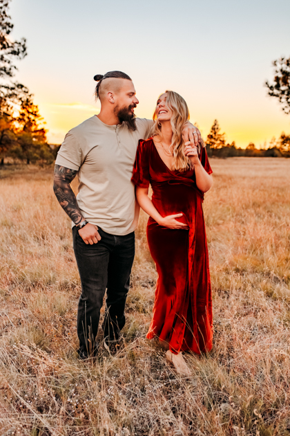 Couple walking through a field laughing at Buffalo Park.