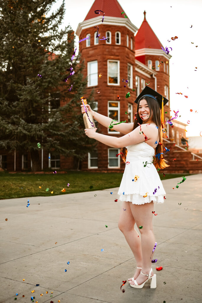 Northern Arizona University senior popping confetti bottle.