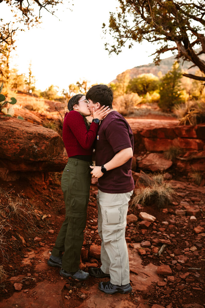 Couple kissing at the red rocks of Bell Rock at sunset.