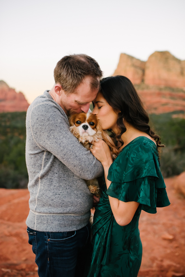 Couple kissing their dog in the red rocks of Sedona.