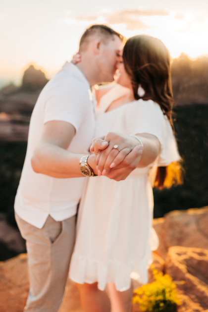 Engaged couple showing off their wedding rings at Merry Go Round Rock in Sedona.