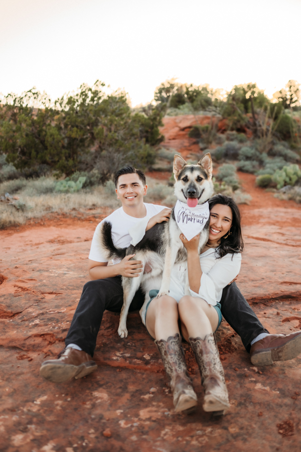 Couple sitting in the red rocks of Sedona at Secret Slick Rock with their dog by Annie Bee Photography.