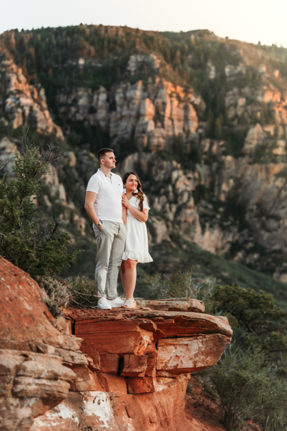 Couple standing on the ledge at Merry-Go-Round-Rock in Sedona, Arizona by Annie Bee Photography.