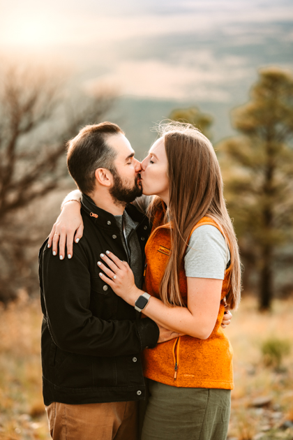 Newly engaged couple kissing after man proposed at Slate Mountain in Flagstaff, Arizona by Annie Bee photography.