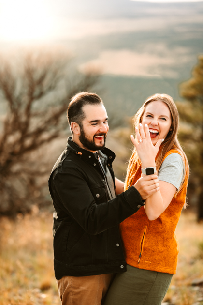 Woman showing off her wedding ring after her boyfriend proposed on the top of Slate Mountain in Flagstaff, Arizona by Annie Bee Photography.