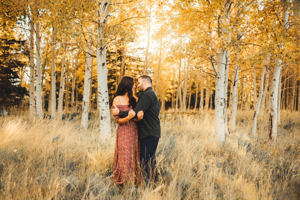 Engaged couple hugging each other at Aspen corner in Flagstaff in a natural life maxi dress.