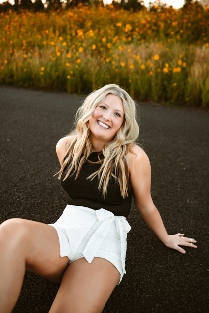 Senior graduation portrait of a girl smiling in the sunflowers of Flagstaff, AZ by Annie Bee Photography.