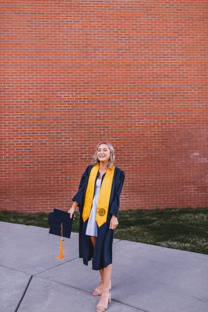 NAU graduate throwing her cap into the air in Flagstaff by Annie Bee Photography.