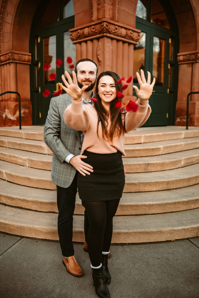 Couple at the flagstaff courthouse throwing rose petals in the air to celebrate a proposal.