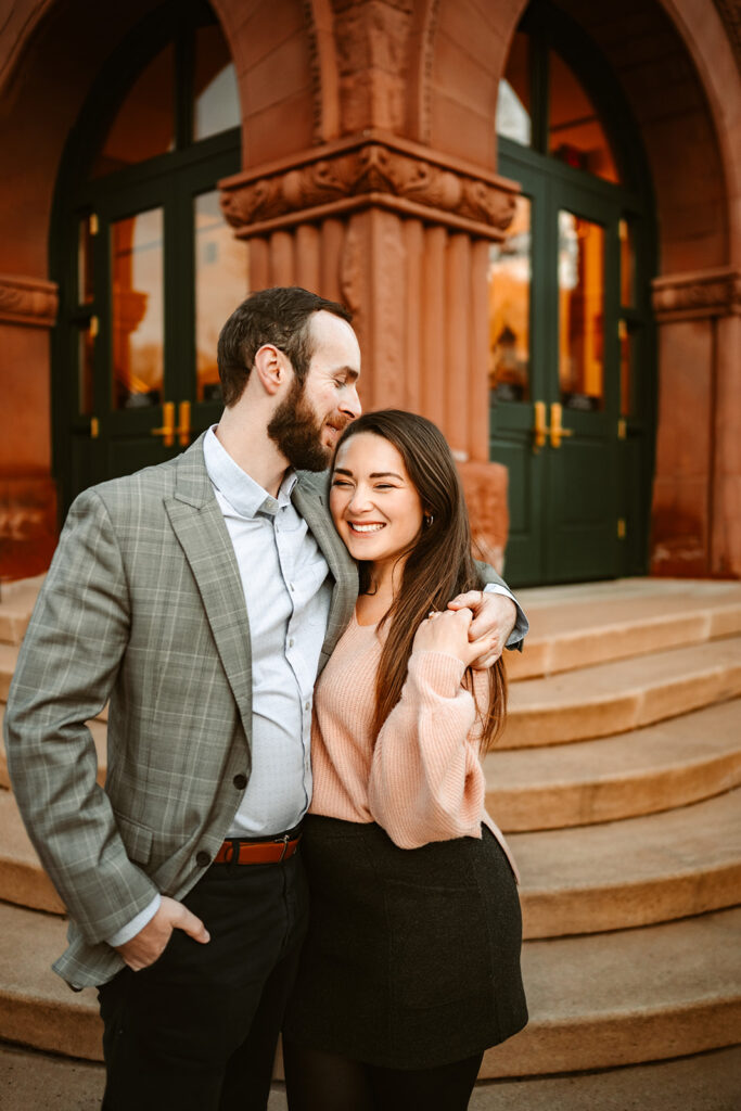 Engaged couple hugging outside the Flagstaff, Arizona courthouse downtown.