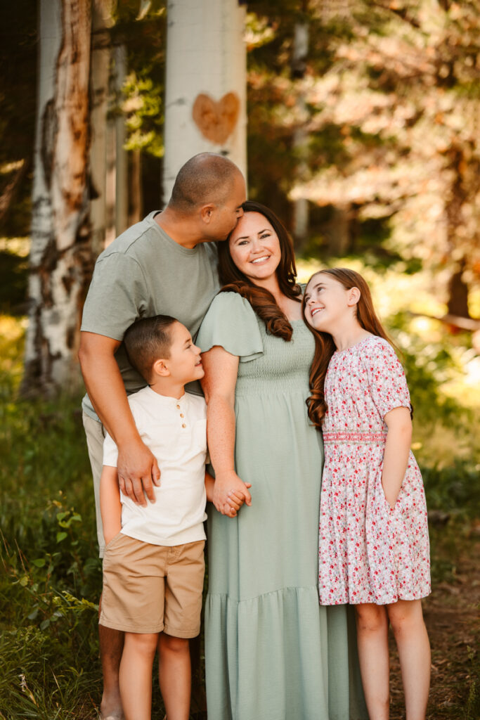 Family kissing in the aspen trees at the best Flagstaff photo locations.