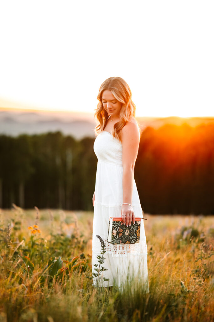 Girl who is graduation holding her bible during a senior session with the mountains behind her.