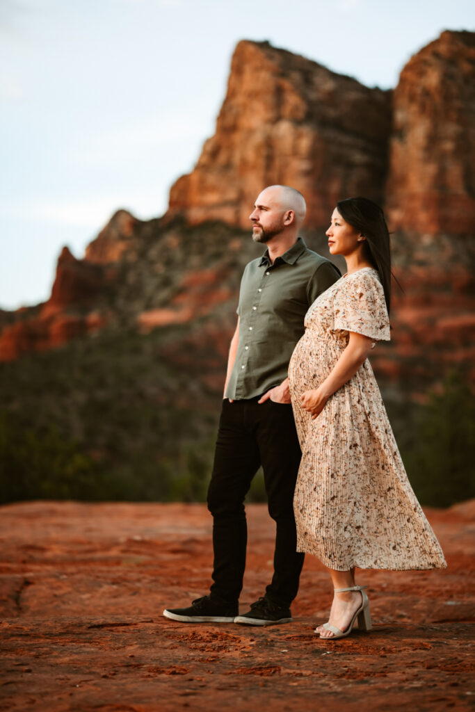 Expecting couple watching the sunset at Bell Rock in Sedona.