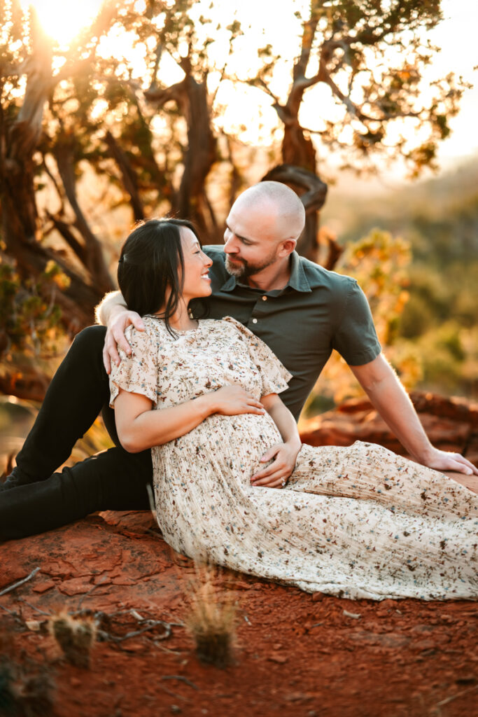 Expecting parents in sedona's red rocks looking at each other.