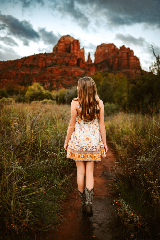 Senior girl walking towards cathedral rock in sedona.