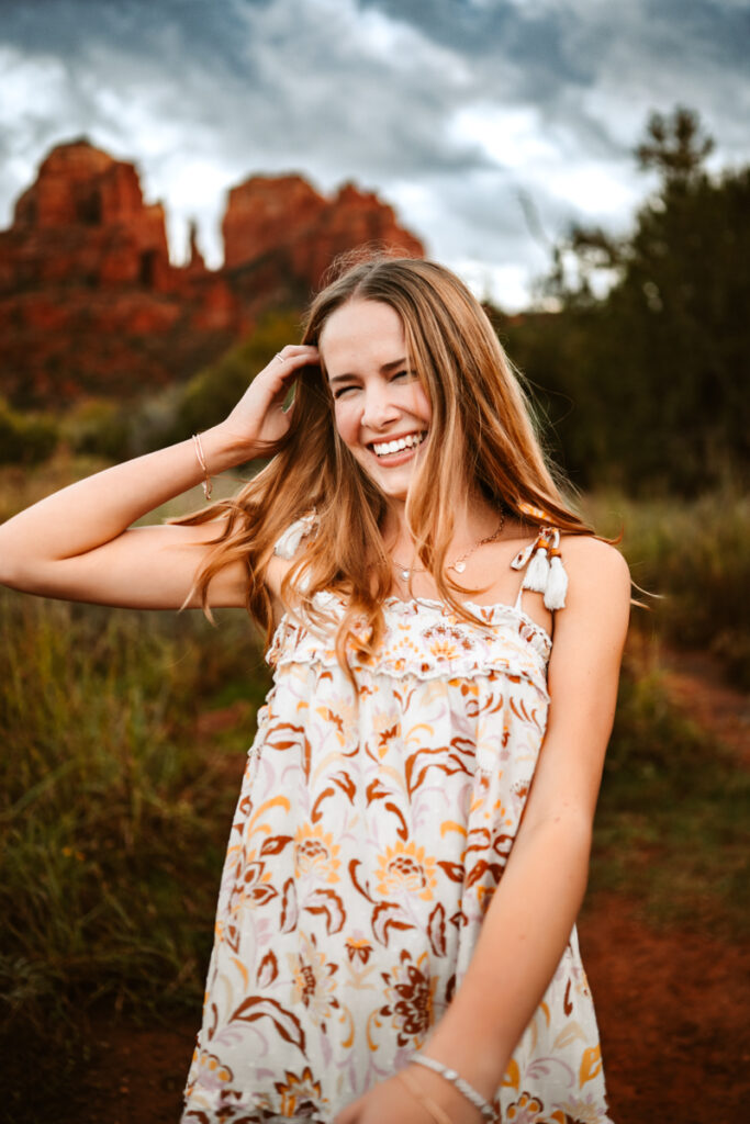 Senior girl laughing in front of cathedral rock.