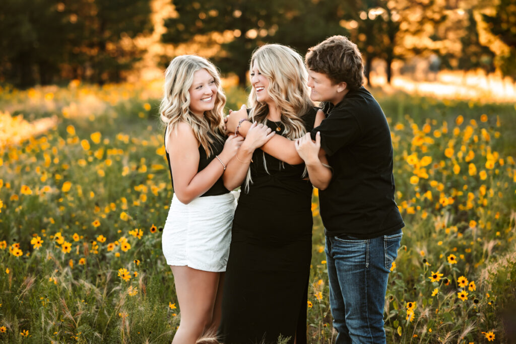 Mother hugging her kids in a field of wildflowers in flagstaff by annie bee photography at the best Flagstaff photo locations.