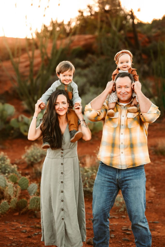 Kids on parents shoulders at sunset in sedona.