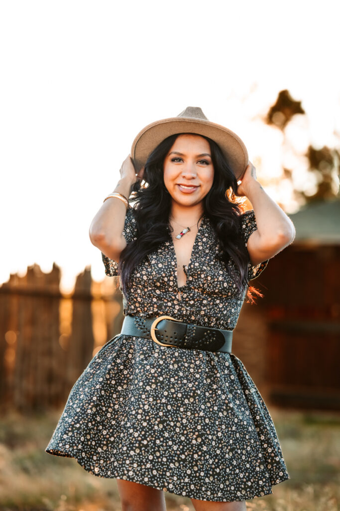 Woman wearing a brimmed hat smiling at buffalo park.