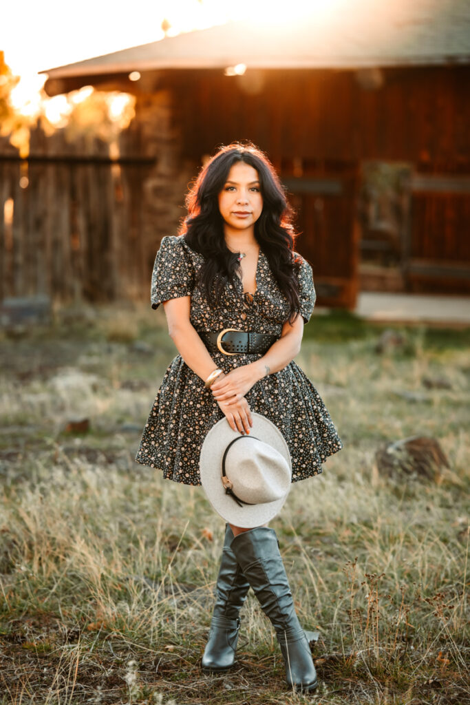 Woman holding a brimmed hat in arizona.